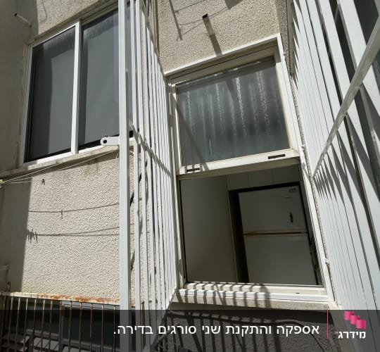 סורגים ישרים ממתכת בצבע לבן המותקנים על חלונות דירה